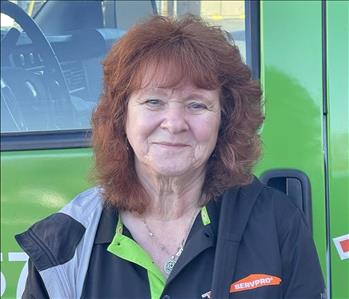 Dianne (Anne) Kelly, our Office Receptionist, standing in front of one of our SERVPRO vehicles.